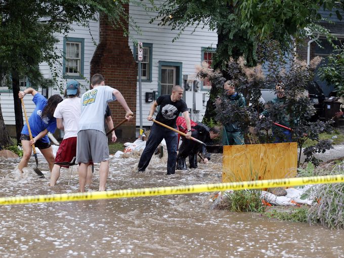 Residents of an apartment building work to divert floodwater from their homes in Boulder, Colo.. Flash flooding in Colorado has cut off access to towns, closed the University of Colorado in Boulder and left at least three people dead.  Ed Andrieski, AP